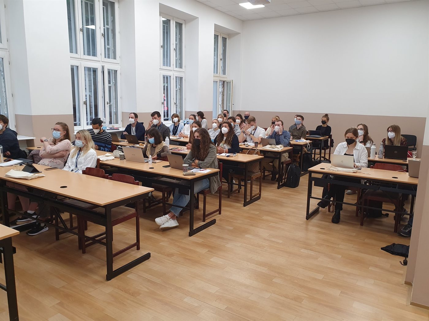 Workshop participants seated at desks with laptops in a classroom