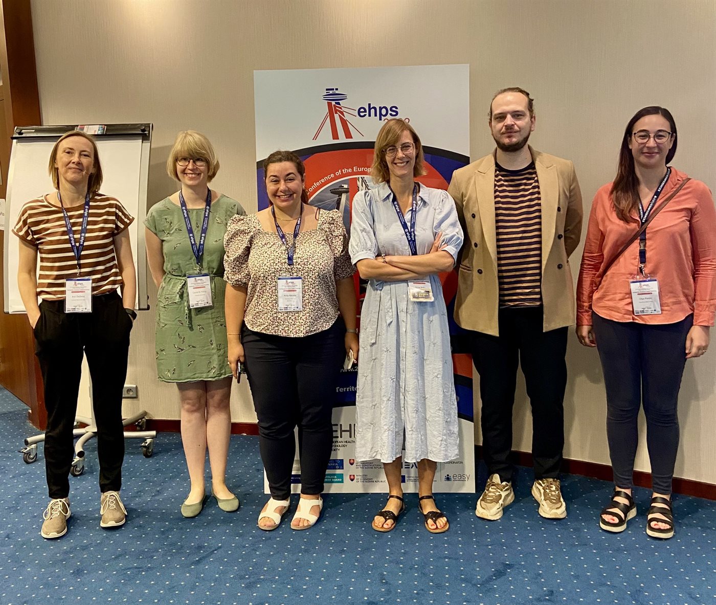 Six colleagues standing in front of an EHPS conference banner