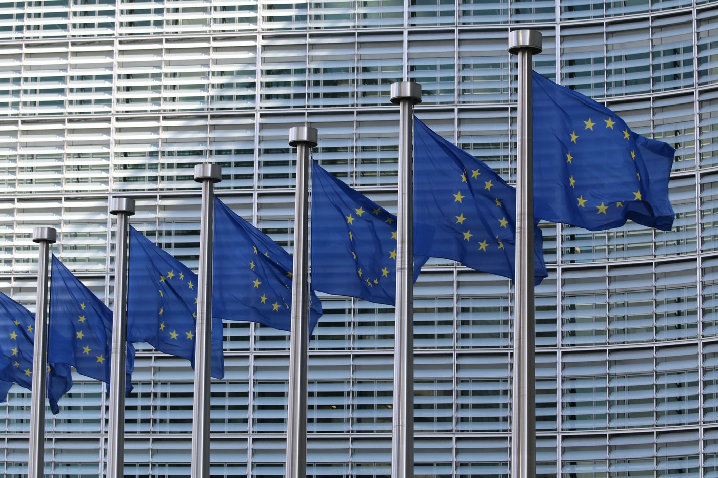European Union flags outside a glass office building